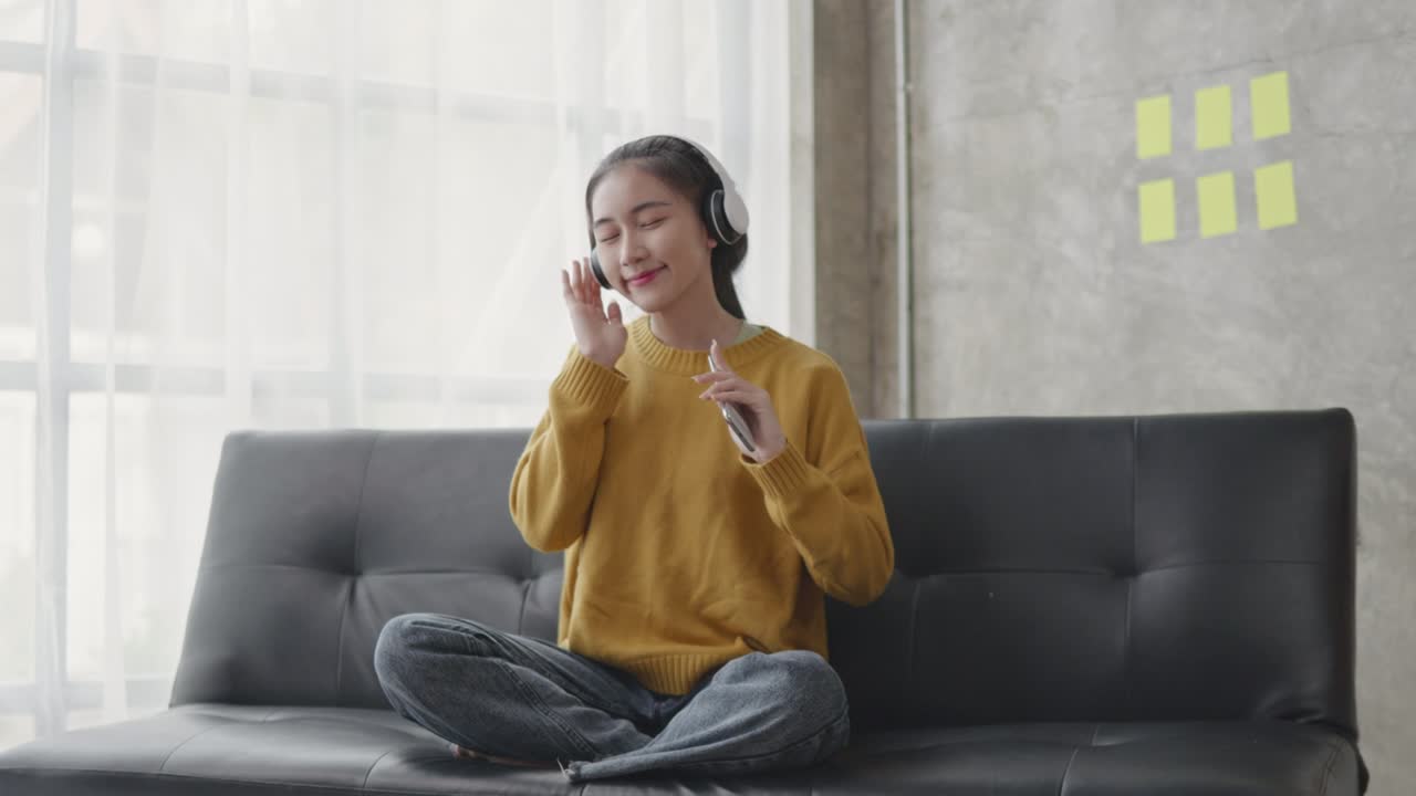 집에서 거실에서 음악을 듣고 있습니다.