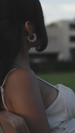 a beautiful woman waits for someone on a park bench