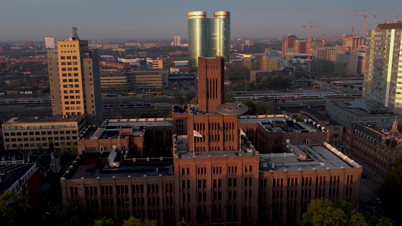 panorámica aérea que muestra el amanecer iluminando el edificio inktpot con ufo descansando en su fachada flanqueada por modernos edificios rascacielos
