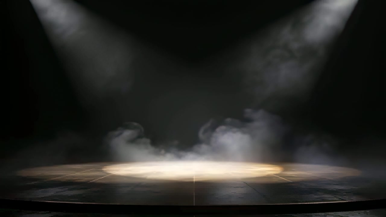Røgmaskine udsender lav røg hen over en cirkulær spotlight-scene i et mørkt teater for at skabe drama.