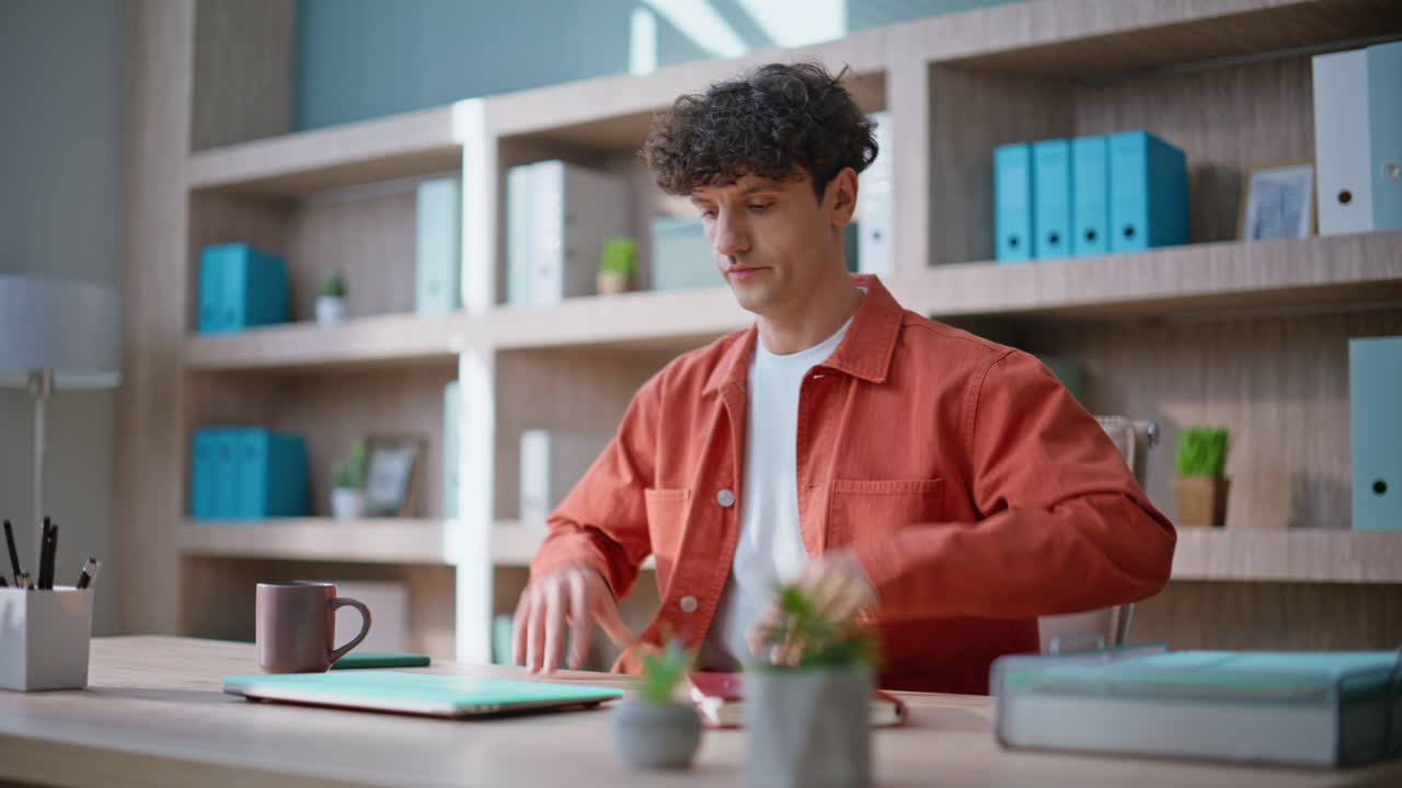 Employee starting work morning sit down at office desk closeup. Man manager