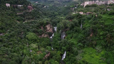 Cascading-waterfalls-in-green-forest,-Tivoli-Italy,-Aerial-toward