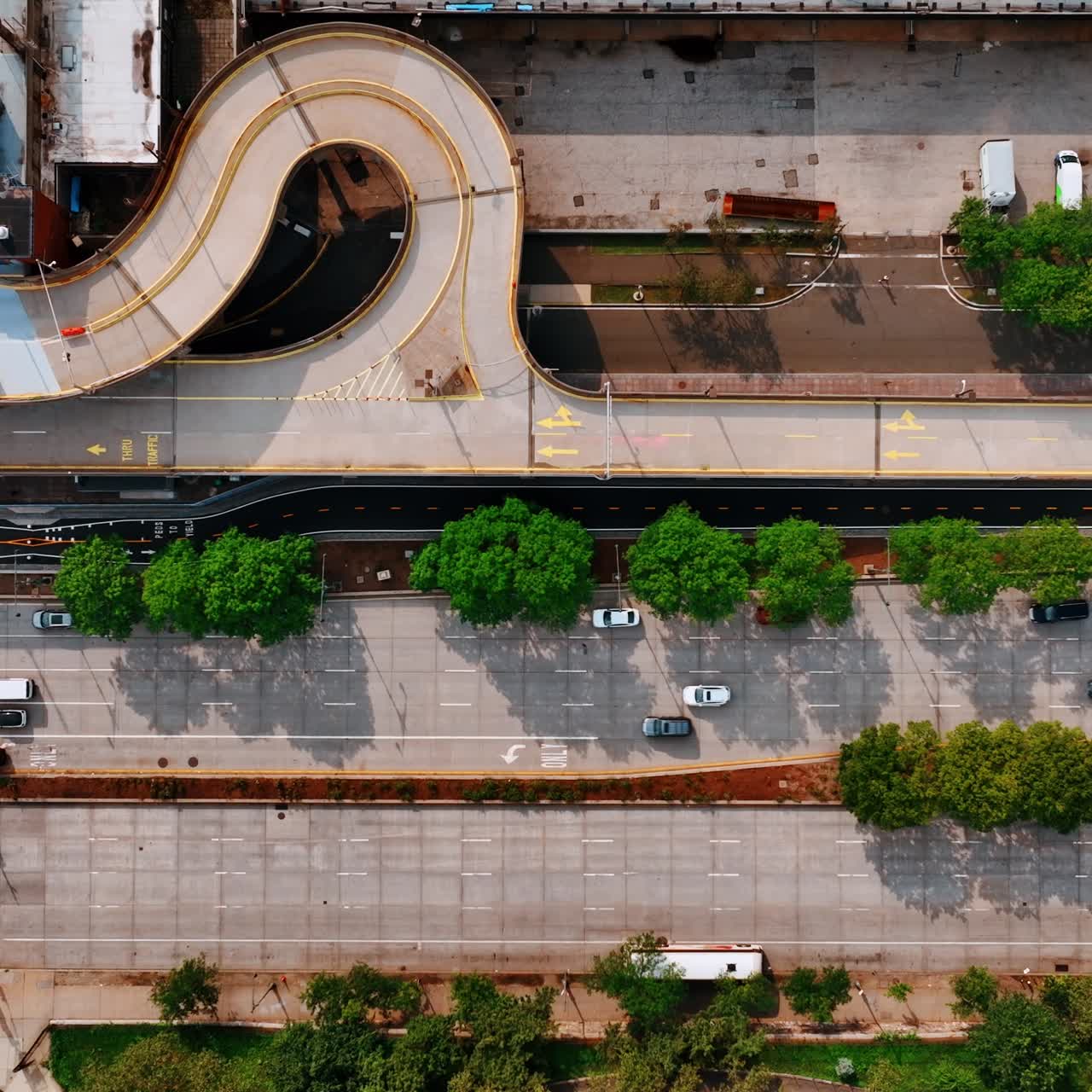 Top view of the road with some cars moving by. Sunny daytime scenery of New York street