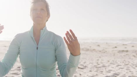 senior woman performing yoga in the beach