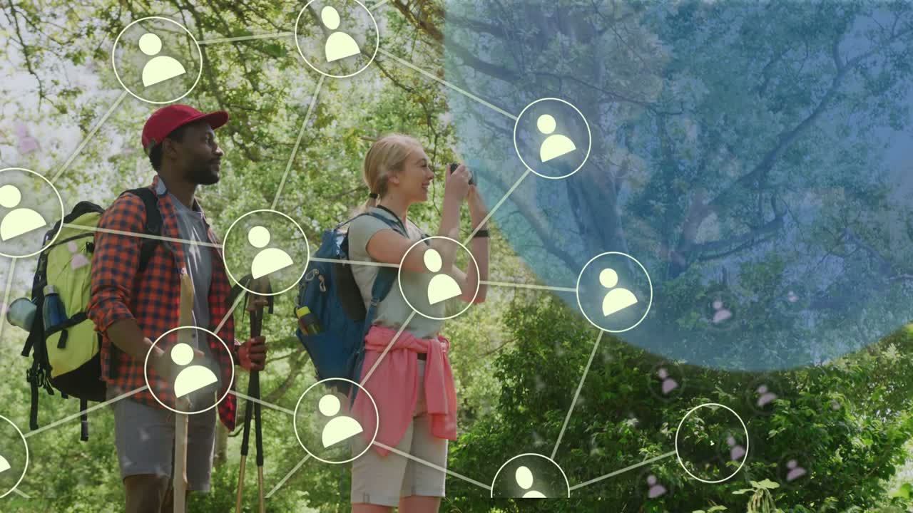 Donna che solleva un dispositivo che cattura un sentiero, uomo che osserva con bastoncini, causando l'espansione di una sovrapposizione di un globo tecnologico