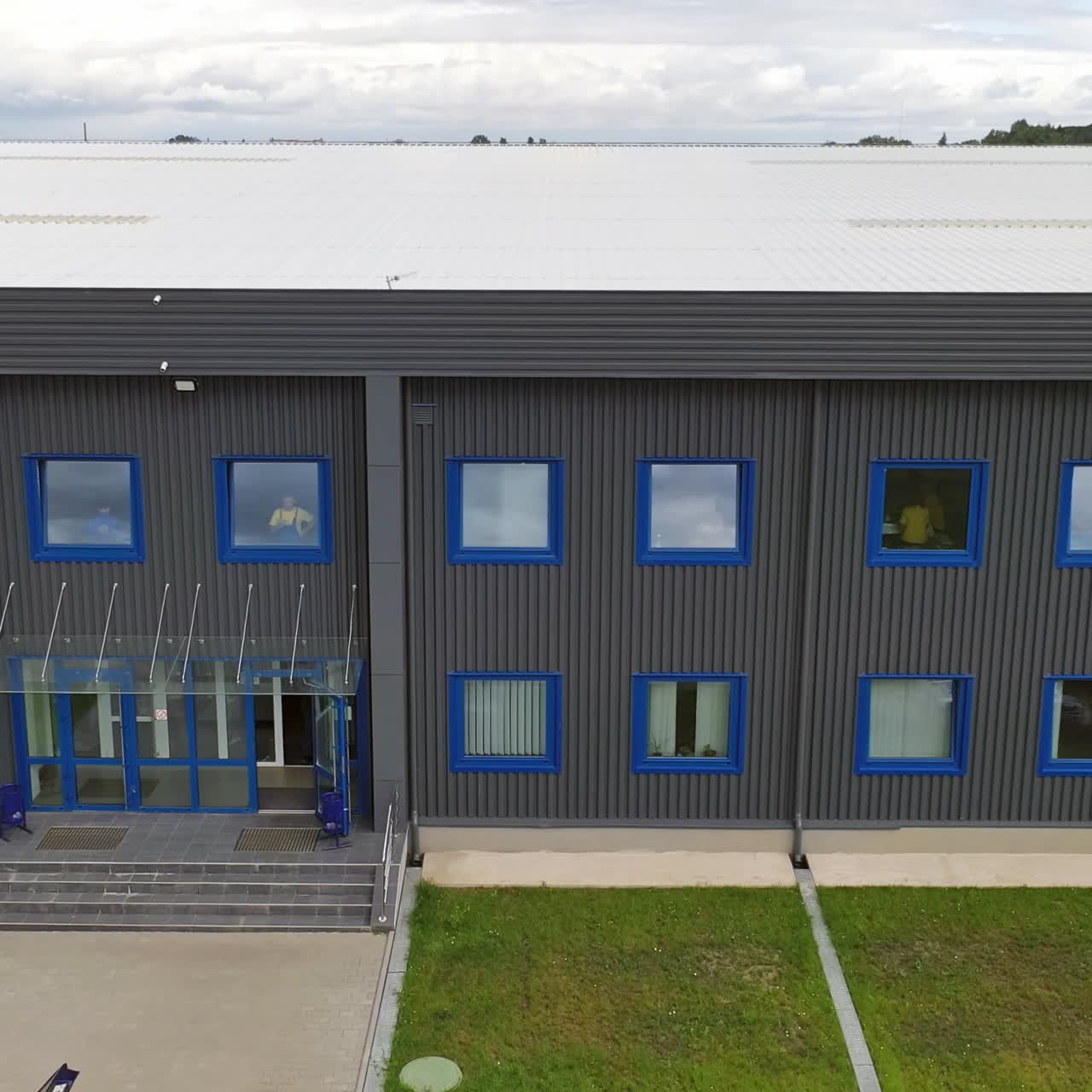 Modern two-storey building. Exterior of a new industrial building. View from outside on a business center in summer time.