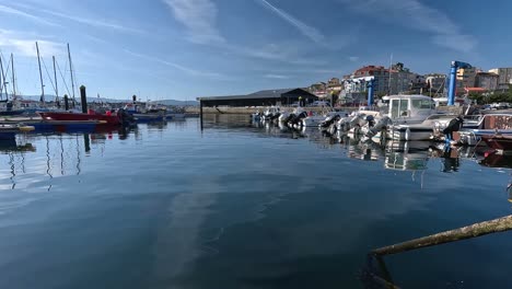 pleasure boats for tourists standing in the calm water of the harbor before the start of the holiday season and tourist industry, revealing shot to the left