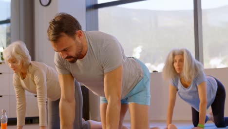 entrenador ayudando a las mujeres mayores en la realización de yoga 4k