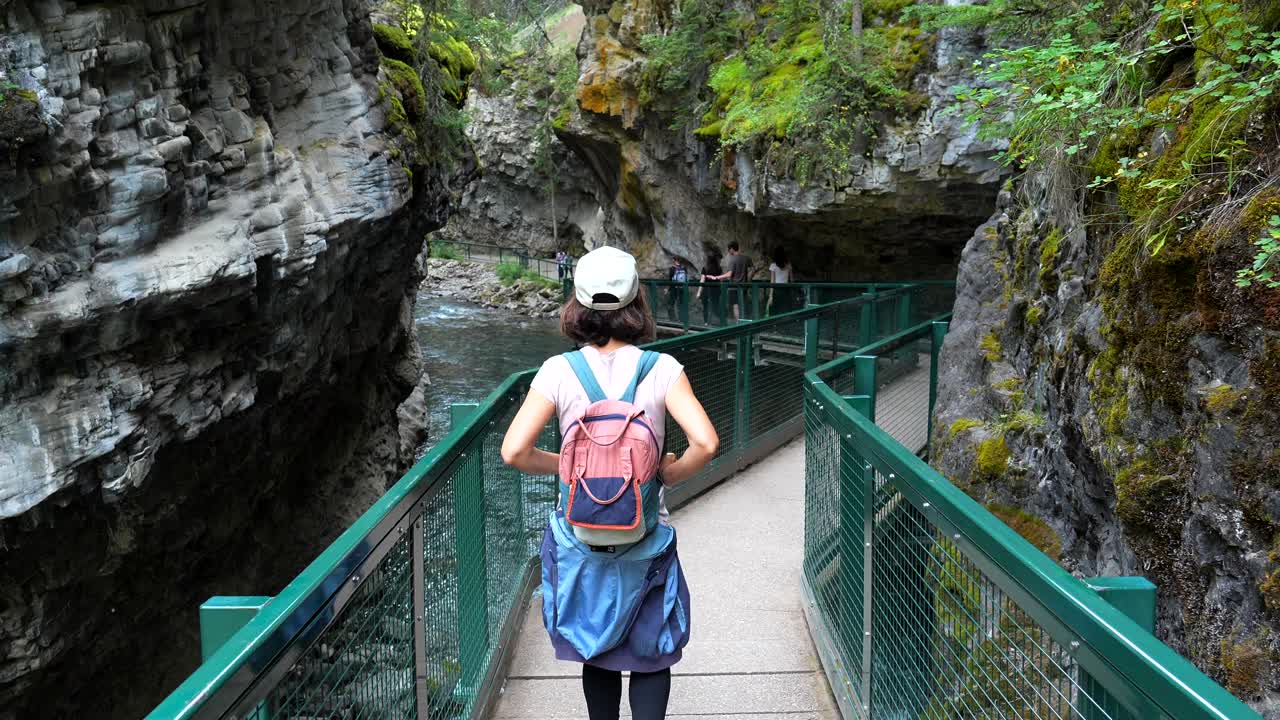 Donna che cammina sulla passerella nel canyon