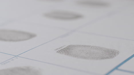 close-up of fingerprint being applied to white paper