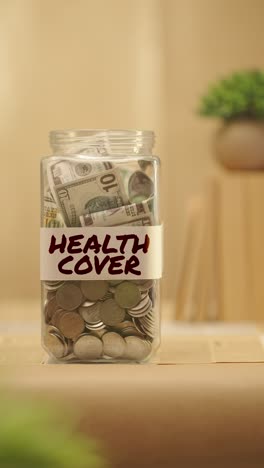 vertical video of person saving money for health cover