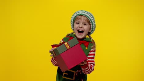 Kid-girl-in-Christmas-elf-Santa-helper-costume-getting,-receiving-present-gift-box.-New-Year-holiday