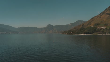 toma aérea de drones de un hombre en un bote en el lago de atitlán, guatemala