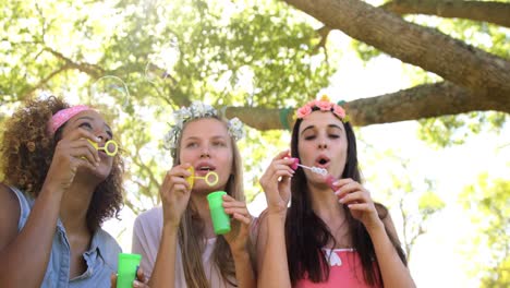 tres amigos hipsters haciendo burbujas de jabón