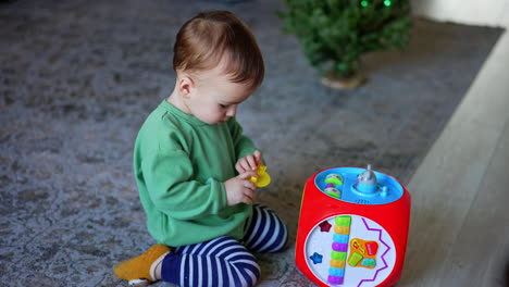 baby playing with educational activity cube