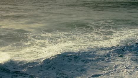 calm rolling waves break along the shoreline in nazare, portugal