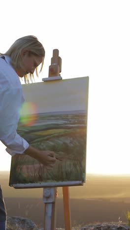 an artist creating a beautiful painting of a scenic landscape during a gorgeous sunset - an artist creating a beautiful painting of a scenic landscape during a gorgeous sunset