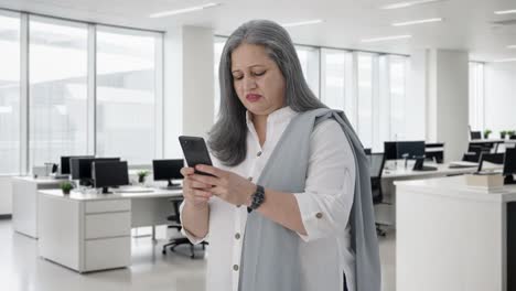 una mujer de negocios india enojada hablando por teléfono.
