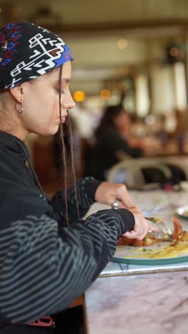 una mujer desayunando en un restaurante.