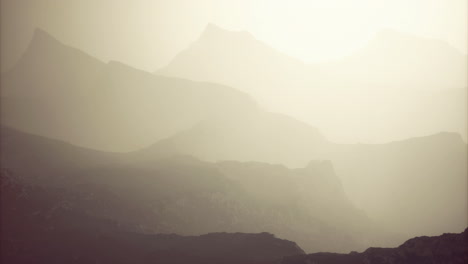 misty mountain landscape at dawn with layered hills in soft sunlight