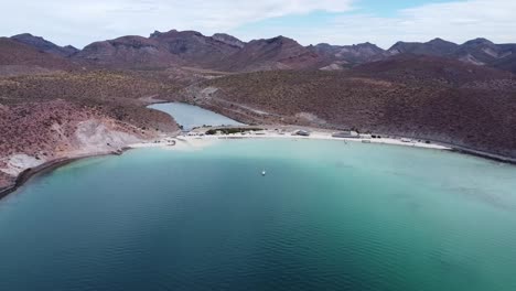 Aerial-view-of-the-breathtaking-Playa-Pichilingue-near-Pichilingue-port-of-La-paz-in-Baja-California-Sur-Mexico-with-blue-sea-with-floating-ships-and-rocky-landscape