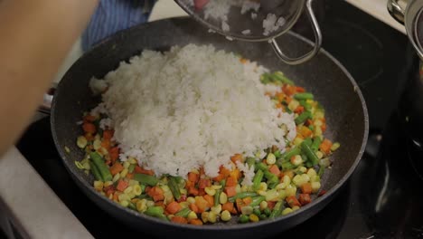 Adding-fig-to-pan-fry-meal-of-delicious-asparagus,-pepper,-corn,-carrot