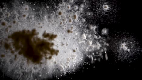 flour falling onto a clear surface, underneath low-angle, slow motion