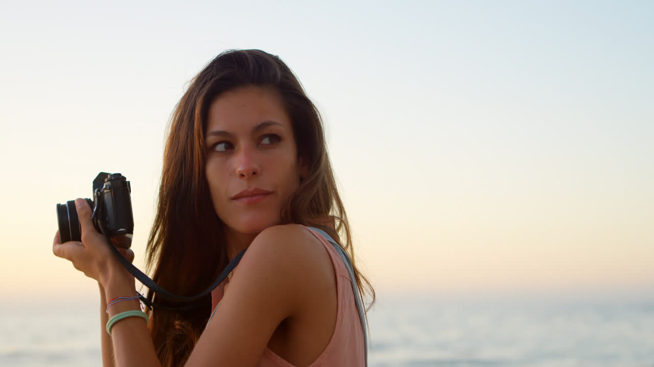 Donna che scatta foto con la macchina fotografica sulla spiaggia 4k