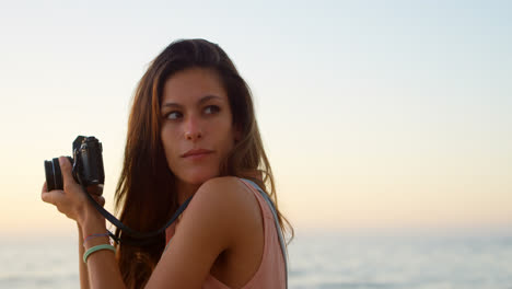 mujer tomando una foto con una cámara en la playa 4k