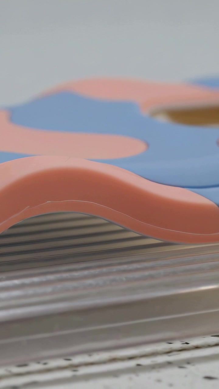 Vertikal video: Bevægeligt kamera viser silikone på plastik over slidt træ, der afslører en bølget kant og et hul.