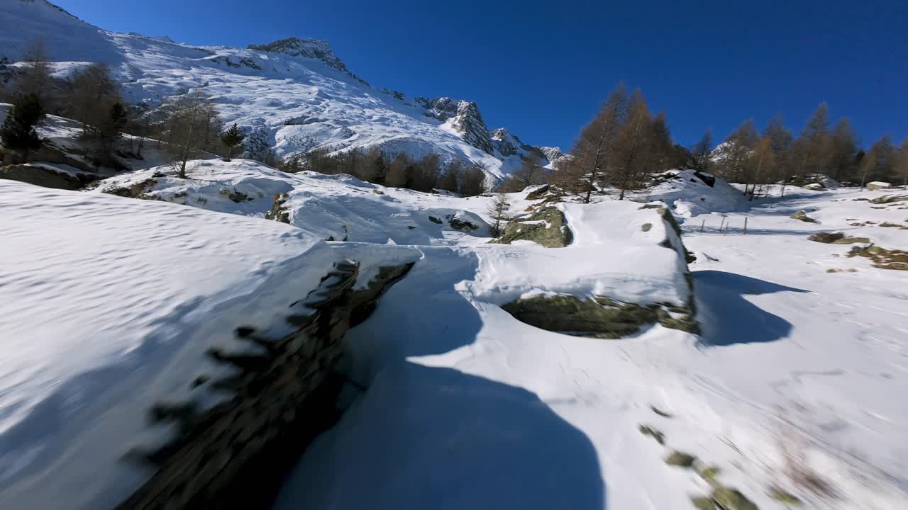 Aerial FPV shot of snow-covered Valmalenco mountains in Italy The landscape features stone