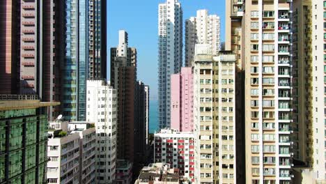toma aérea de mega rascacielos residenciales y tráfico en el centro de hong kong, en un hermoso día