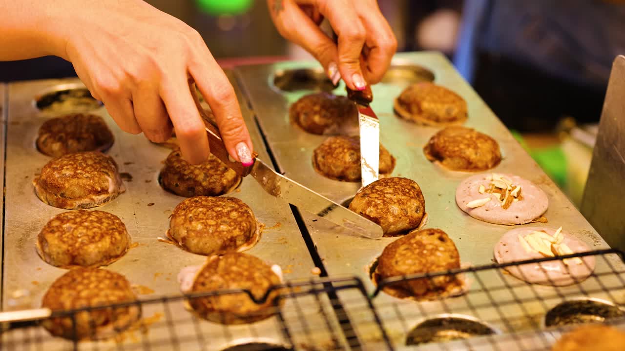 손은 그릴 위에 전통적인 태국 디저트를 준비하고 있습니다.