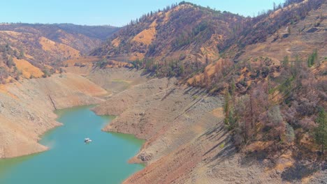 Erstaunliche-Luftaufnahme-über-Dem-Von-Dürre-Betroffenen-Kalifornischen-See-Oroville-Mit-Niedrigem-Wasserstand,-Zurückweichender-Küstenlinie-Und-Verbrannten-Bäumen-Und-Wäldern