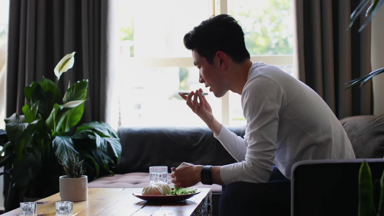 居間4kで携帯電話で話している男性