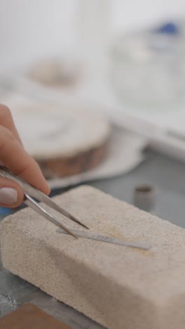 close-up of a hand using tweezers for precise work in a workshop