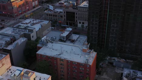 Aerial-footage-pans-up-across-the-Harlem-neighborhood-of-NYC-to-dramatically-reveal-the-mighty-George-Washington-Bridge-in-the-distance,-at-beautiful-sunrise-golden-hour