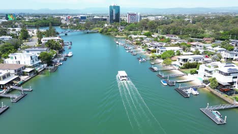 ferry on gold coast canal, cruising past luxury waterfront homes on a brilliant queensalnd day