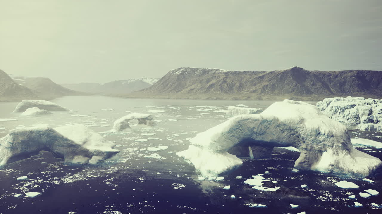 Icebergs floating in calm waters by mountains on a peaceful day
