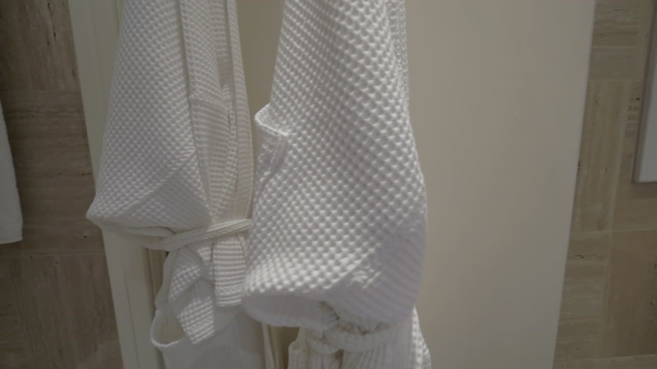 дверь ванной комнаты с двумя чистыми халатами