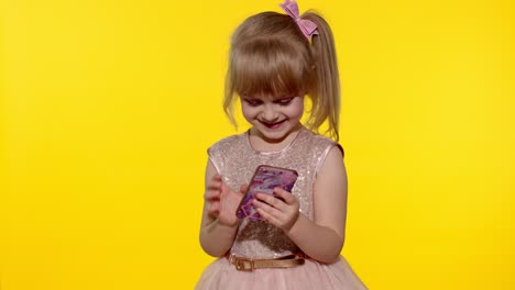 Child-girl-in-dress-using-mobile-cell-phone,-found-out-great-big-win-news.-Kid-doing-winner-gesture