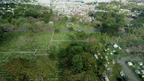 Drone-Shot-of-empty-cemetery-with-cars-passing-by-in-The-Philippines