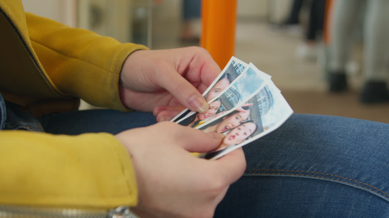 close up de una mujer sentada en un tren subterráneo mirando fotos tomadas con un amigo