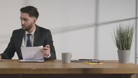 businessman in office reviewing and making notes on application or cv for job vacancy 1