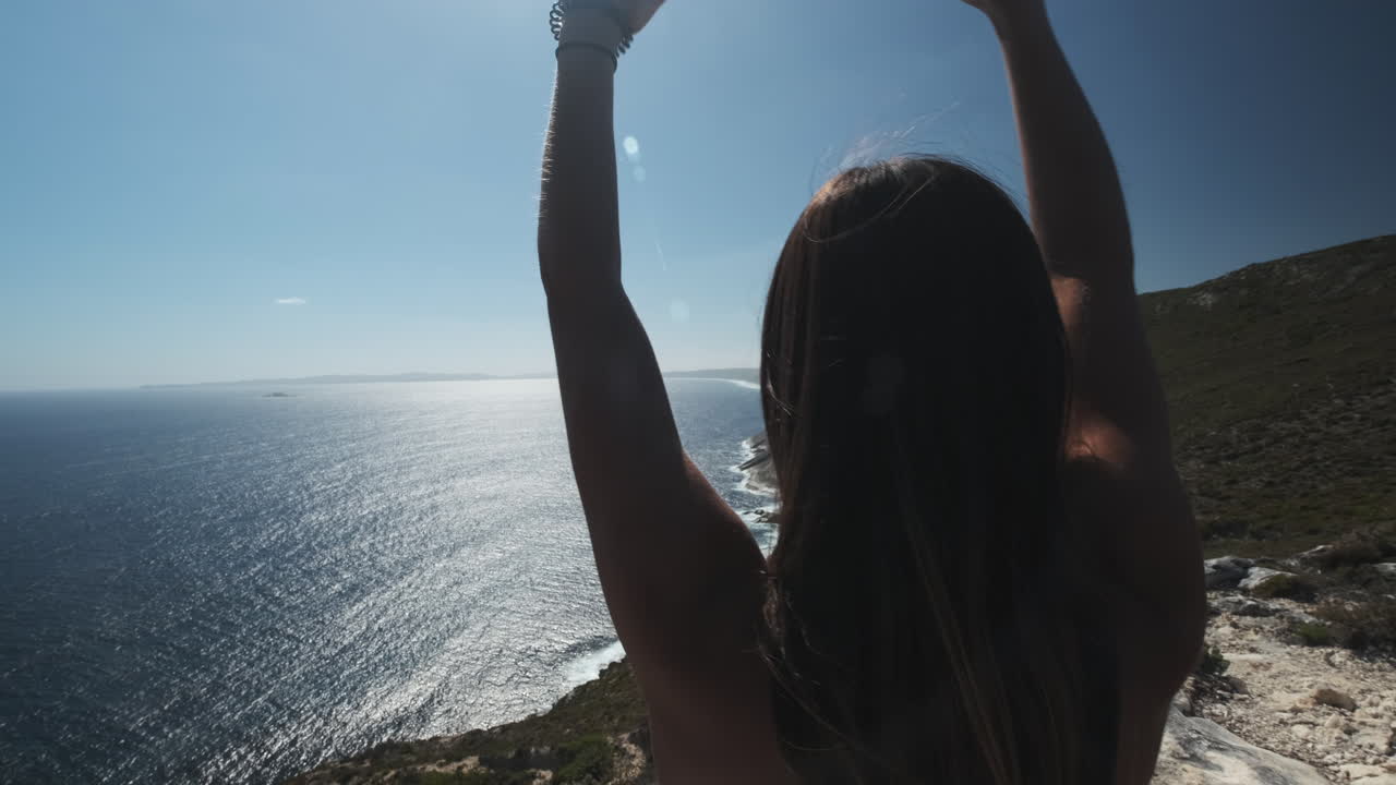 Woman enjoying the breathtaking ocean view from a clifftop
