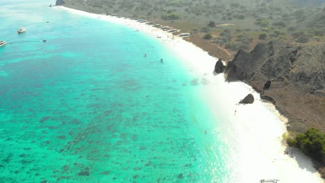 agua turquesa, playa de arena y colinas escarpadas de la playa rosada en la isla de padar en el parque nacional de komodo, indonesia