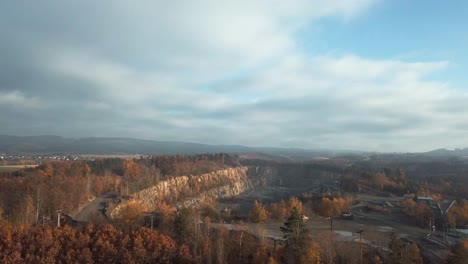 Forward-aerial-top-view-over-colourful-autumn-forest-in-sunny-day-with-some-clouds