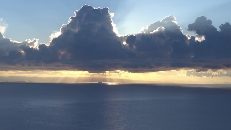 Spectacular horizon view of sun hiding behind clouds in peaceful lake Titicaca, static, real time