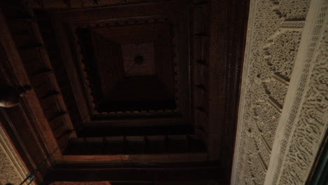 intricate wooden ceiling in an old arabic mausoleum in tunis with ornate details and dim lighting