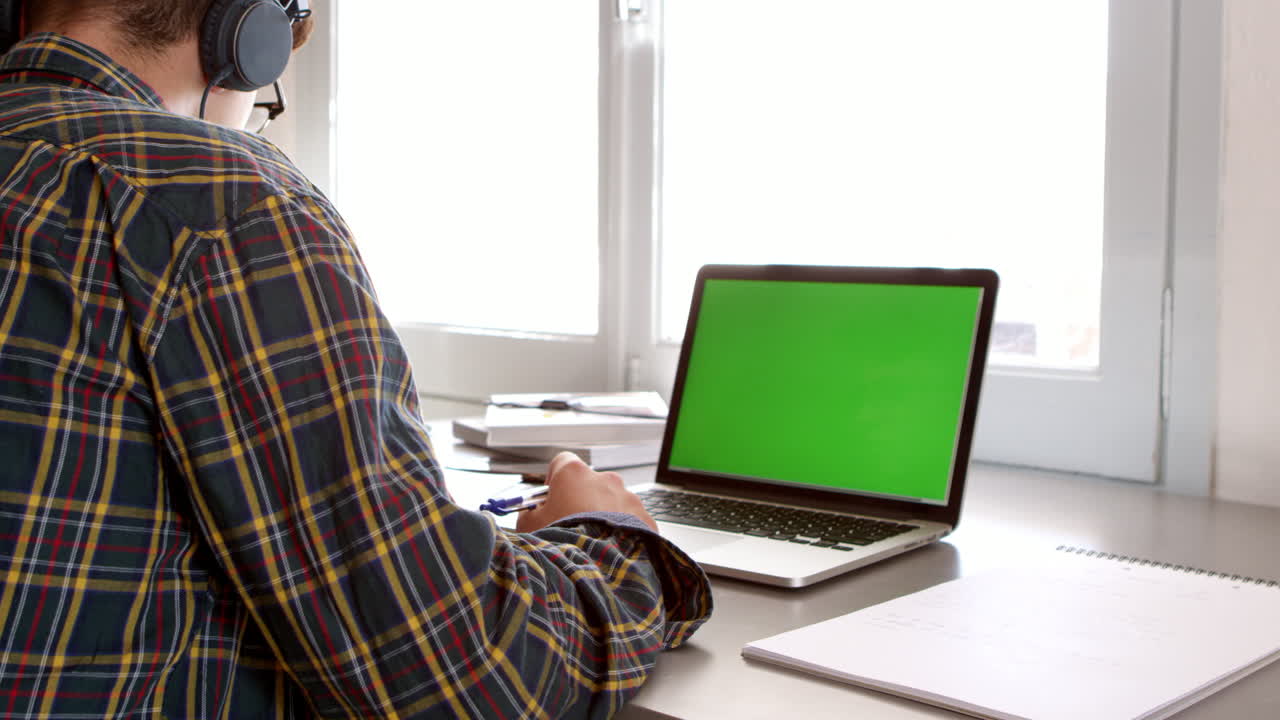 adolescente con auriculares trabaja en el escritorio en su dormitorio, filmado en r3d